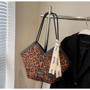 Dettaglio della borsa tote leopardata con manici neri ed etichetta moda elegante