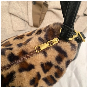 Détail du sac en peluche léopard avec fermeture éclair dorée et bandoulière en cuir