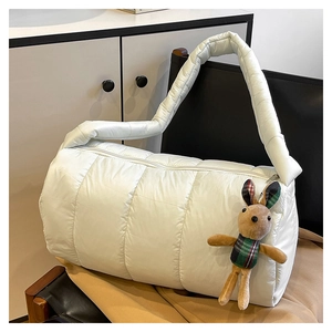 Detailed view of white quilted puffer shoulder bag with a cute rabbit plush pendant accessory