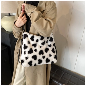 Détail du sac à bandoulière en peluche avec motif cœur et boucle métallique réglable