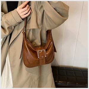 Detail der braunen Hobo-Tasche mit großer Silberschnalle und glatter Lederoptik