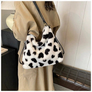 Détail du sac en fausse fourrure blanche à motifs cœurs avec bandoulière en cuir noir