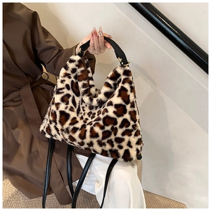 Détail du sac à main en peluche léopard avec poignées en cuir noir et finitions dorées