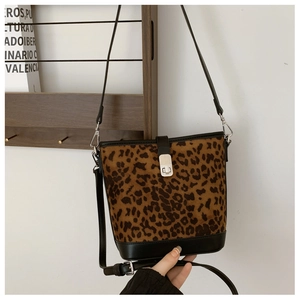 Close-up of leopard print bucket bag with metal twist lock and black leather trim