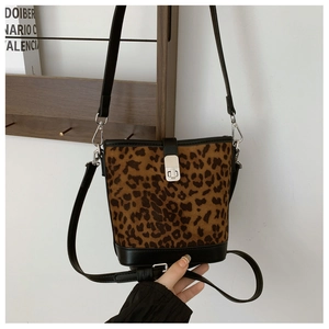Close-up of leopard print bucket bag featuring black leather trim and silver metal twist lock
