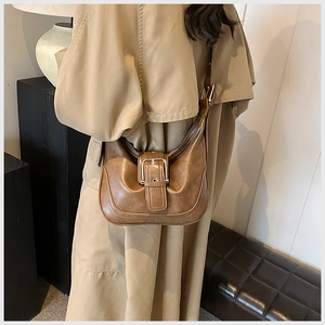 Detail der braunen Vintage-Leder-Hobo-Tasche mit Metallschnalle an einem Model