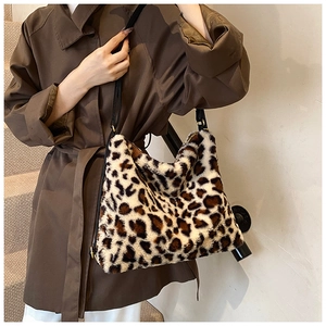 Détail du sac fourre-tout léopard en peluche avec de longues bandoulières noires élégantes