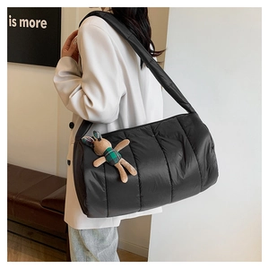 Detail of black quilted puffer bag with a cute plaid rabbit plush pendant for women