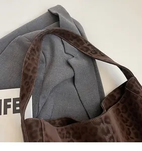 Detail of sturdy shoulder strap stitching and leopard print plush fabric texture
