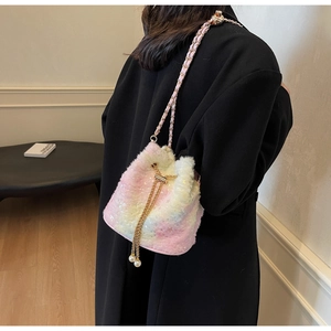 Detail of gradient plush bucket bag with pearl drawstring and golden chain strap