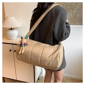 Quilted khaki puffer shoulder bag with a cute rabbit plush charm shown on a model