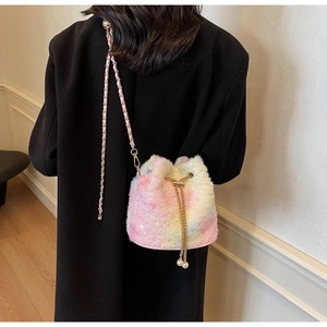 Detail of plush bucket bag featuring soft pastel gradient faux fur and pearl drawstring