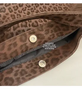 Detail view of the silver magnetic closure on a leopard print fabric shoulder bag