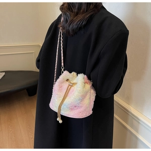 Detail of plush tie-dye bucket bag with gold chain and faux pearl drawstring accents