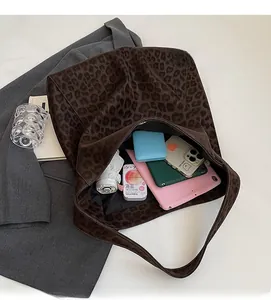 Top-down view of a leopard print tote bag showing spacious interior with personal items