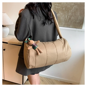 Quilted khaki puffer shoulder bag detail with cute teddy bear charm on wide strap