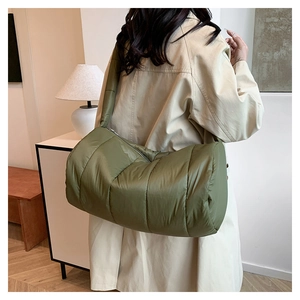 Olive green quilted puffer shoulder bag shown on model for size and fit reference