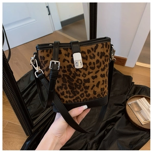 Detail of leopard print bucket bag with silver twist lock and black leather trim