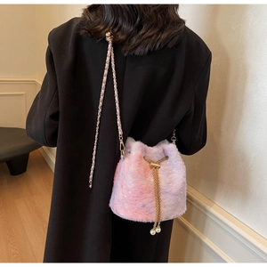 Detail of plush gradient bucket bag with gold chain strap and pearl drawstring accents