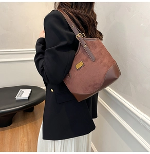 Detailansicht einer braunen Vintage-Schultertasche aus mattem Leder mit Goldbeschlägen