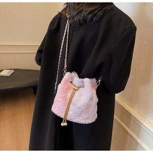 Detail of plush gradient bucket bag with star sequins, gold chain, and pearl accents