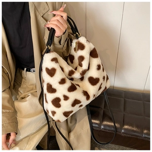 Détail du sac cabas en peluche crème avec motifs cœurs et bandoulière noire