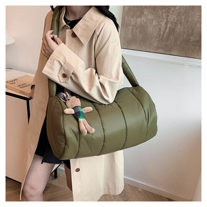 Olive green quilted puffer pillow bag with a cute rabbit charm shown on the model