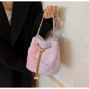 Detailed shot of gradient faux fur bucket bag with star patterns and gold chain strap