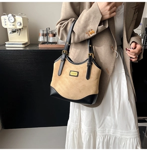 Detail der khakifarbenen Wildleder-Schultertasche mit schwarzem Leder und Goldbeschlägen