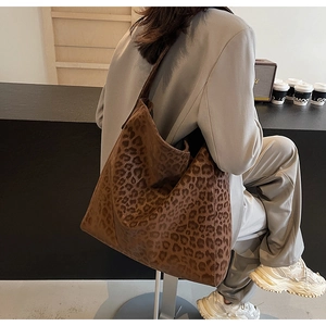 Close-up of leopard print tote bag with soft texture worn on shoulder in a cafe