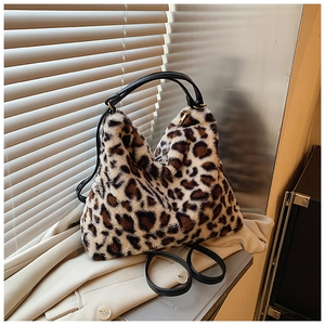 Détail de la texture en fausse fourrure léopard sur un sac à main avec zip doré