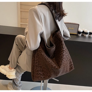 Large leopard print tote bag styled with casual grey suit for a trendy urban look
