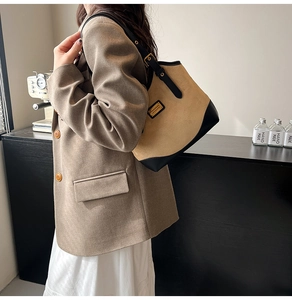 Schultertasche aus Canvas und Leder am Modell mit lässigem Retro-Styling getragen