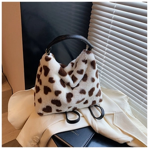 Détail d'un sac à dos en fausse fourrure blanche douce avec motifs de cœurs et lanières noires