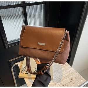 Details der braunen Vintage-Umhängetasche mit Leder-Mix und modischem Kettenriemen