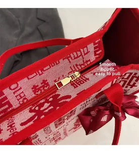Detail of smooth gold metal zipper and silk ribbon on red bridal canvas tote bag