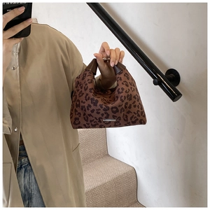 Makro-Detail der Hobo-Tasche mit Leopardenmuster, Metall-Logo und Ledergriff im Detail