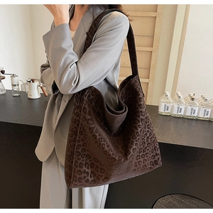Close-up of a large leopard print tote bag in soft velvet fabric shown on shoulder