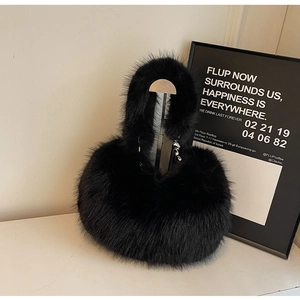 Détail d'un sac à main en fausse fourrure noire avec poignée douce et détails en métal