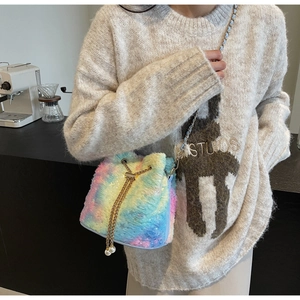 Detail of plush rainbow bucket bag with gold chain strap and pearl drawstring accents