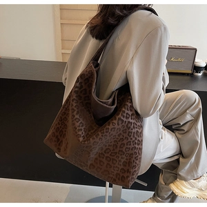 Close-up of leopard print tote bag with soft suede texture shown on a female model