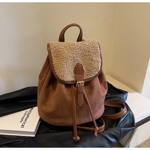 Detail of suede backpack with sherpa flap showing drawstring and buckle closure