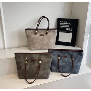 Three large tote bags in beige, grey, and blue with marble texture and slim brown straps