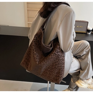 Close-up of a large leopard print hobo tote bag with soft texture and wide shoulder strap