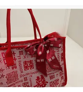 Detail of red wedding tote bag featuring double happiness patterns and silk ribbon bow