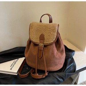 Detail of faux suede and fleece backpack next to a book on a stylish leather jacket