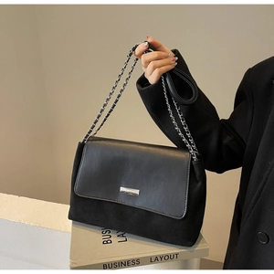 Detailansicht der schwarzen Vintage-Tasche mit Wildleder-Struktur und Silberplakette