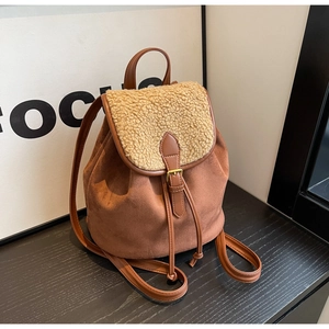 Detail of vintage brown suede backpack with fuzzy faux fur flap and buckle closure