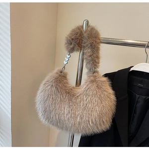 Gros plan sur la texture en fourrure et les boucles de cœur argentées du sac à bandoulière