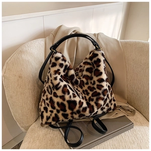 Détail d'un sac à bandoulière en fausse fourrure léopard sur une chaise beige chic